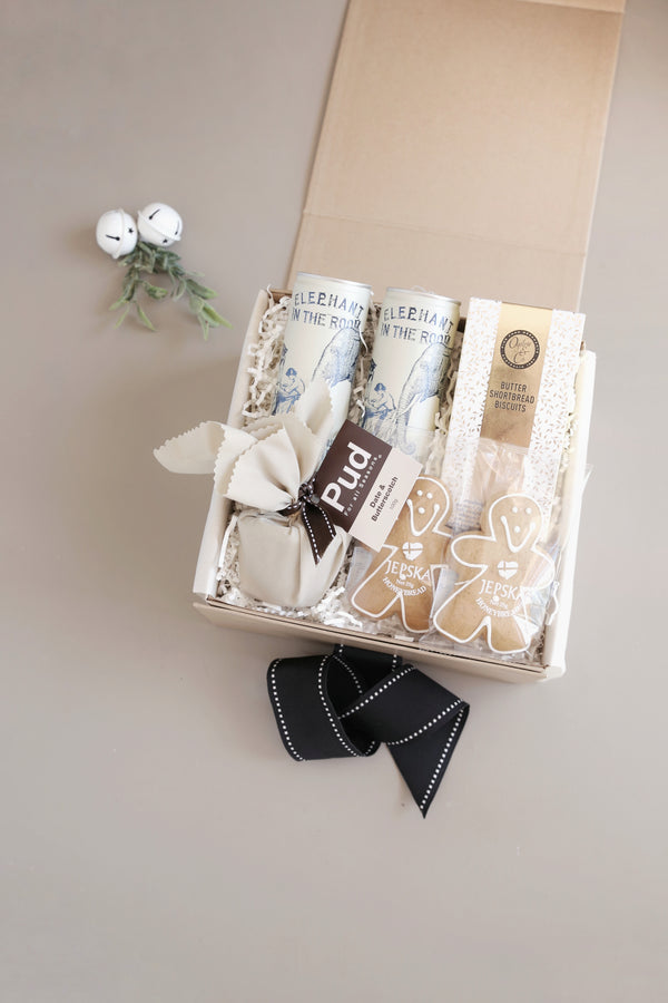 Opened luxury Christmas Hamper with pinot noir surrounded by gourmet pudding gingerbread and cookies for Say It With A Box Sydney